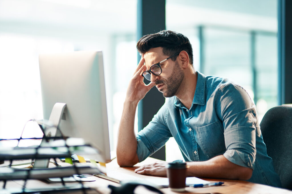 Stress headache and frustrated business man working on computer in an office annoyed and anxious male under pressure from a workload and deadline depressed guy experiencing burnout at work - optima health Stress, headache and frustrated business man working on computer in an office, annoyed and anxious. Male under pressure from a workload and deadline.